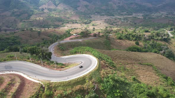 Aerial view of mountain road through tropical forest in countryside of Asia by drone