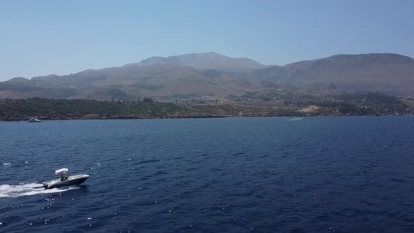 Speedboat Sailing At The Deep Blue Sea With Mountain Landscape On The Background In Scopello, Trapan alt