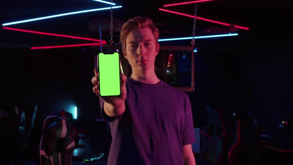 An Experienced Gamer Guy Advertises the Phone Holds It at Arms Length Shows the Screen