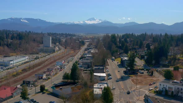 Flying Above a Scenic Mountain Town near Mt Baker as Cars Pass on the Streets Below alt