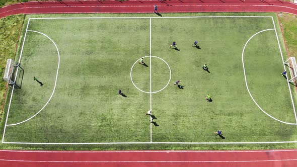 Aerial View Children Play Football on a Small Football Field. Modern Football Ground Near the School alt