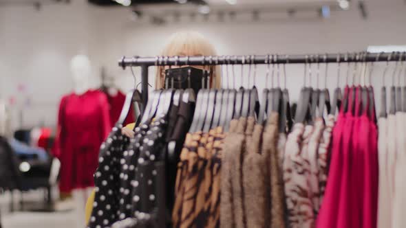 Mature Caucasian Female Sales Assistant in Protective Mask Dances in Clothing Store Advertises New alt