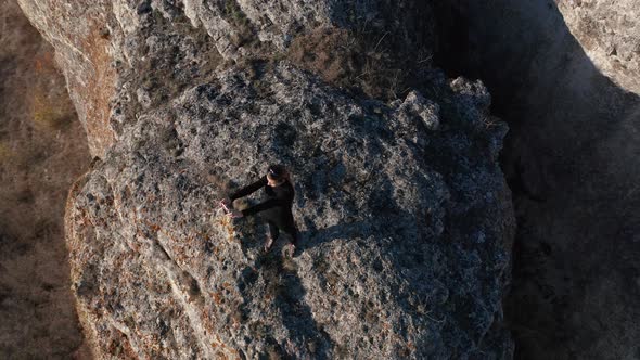 Woman taking pictures on her smart phone while standing at the edge of stunning rock formation