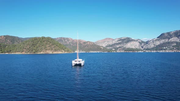 Catamaran Sail in Front of Mountains of Turkey By the Sea alt