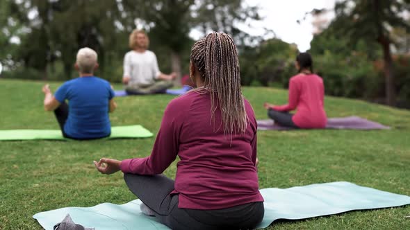 Multiracial people doing yoga exercise with social distance for coronavirus outbreak at park
