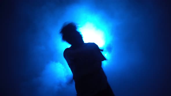 Silhouette Man Street Dancer Dancing in Smoky Room with Backing Blue Neon Light alt