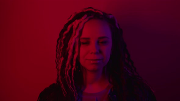 Young Woman with Curly Hairstyle Posing in Dark Room alt