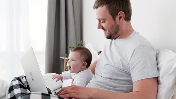 Father with Child and Laptop in the Bed alt