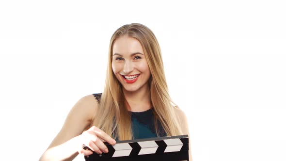 Elegant Woman with Sexy Red Lips Holding Clapper Board and Smiling, on White alt