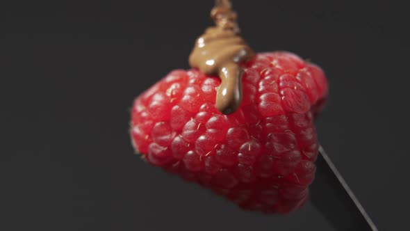 Melted Chocolate Flows on Raspberry Close Up