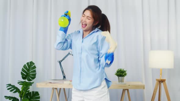 Asia woman holding spray microphone singing song music in modern living room alt