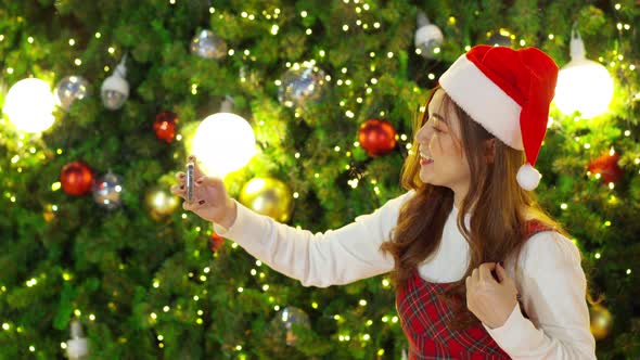 happy woman using smartphone with Christmas tree, x-mas celebrating