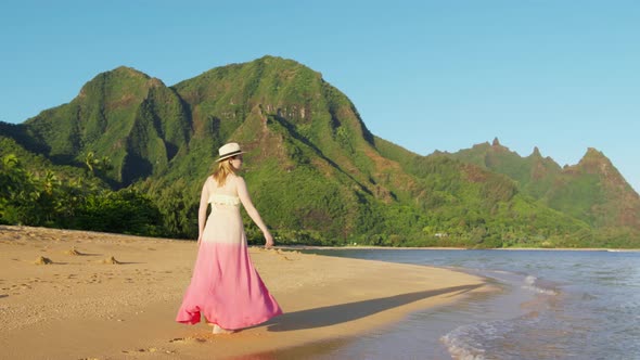 Woman in Pink Flattering Dress Walks By Beach on Kauai Tropical Island at Napali alt
