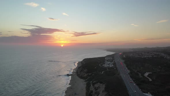 Aerial 4k view of a sunset illuminating stunning beach front luxury homes. alt