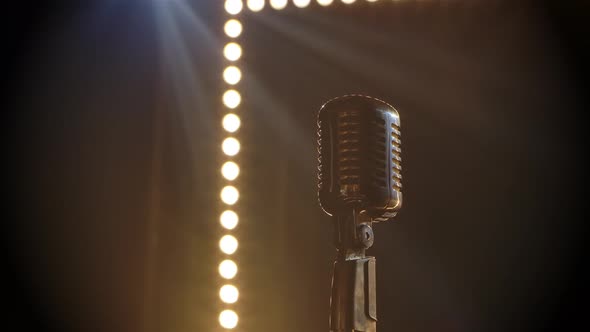 Microphone on Stage with Smoke Anding Light Behind It. Professional Concert Vintage Glare Microphone alt