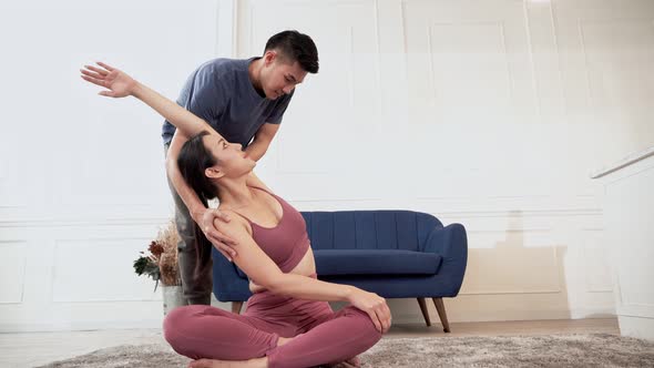 Asian man help woman practicing yoga and stretching body