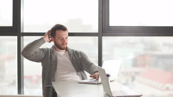 Concentrated European Young Clerk in Spectacles Looking at the Laptop alt