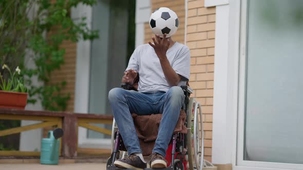 Portrait of Paraplegic African American Sportsman Spinning Ball on Finger in Slow Motion Thinking alt