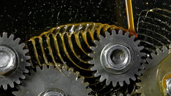 Super Slow Motion Shot of Gear Mechanism and Oil on Dark Background at 1000 Fps alt