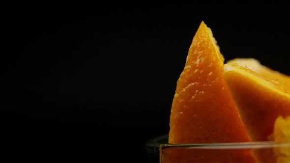 Orange Slices In A Glass Plate On A Black Background Spins