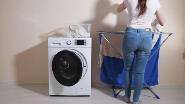 Lady Takes Laundry of Washing Machine and Hangs Out on Rack alt
