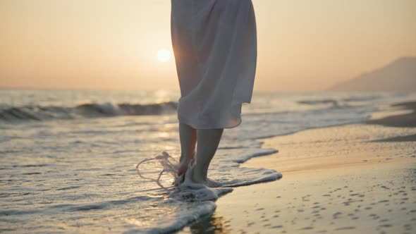 Attractive young woman in a white summer dress by the sea alt
