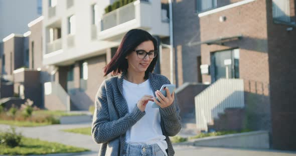 Portrait of Happy Caucasian Woman Typing by Mobile Phone Outdoors at Sunset alt