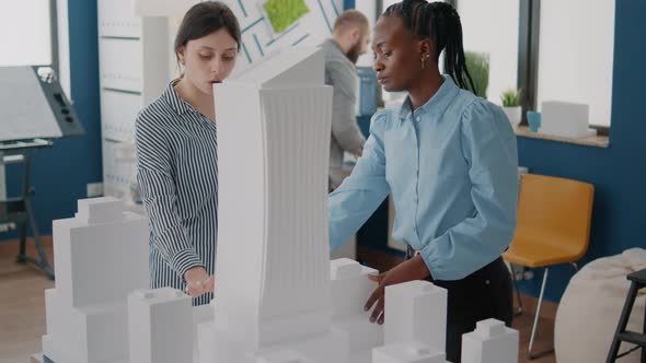 Architects Working with Building Model to Plan Construction Layout alt