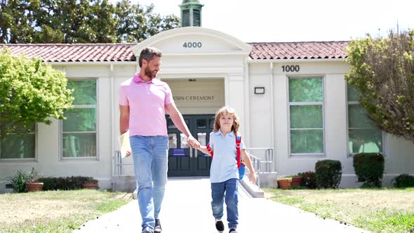 Happy Man Teacher and Boy Pupil Walking Out of School Slow Motion First Grade