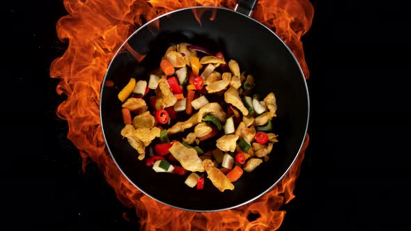 Super Slow Motion Shot of Throwing Chicken Meat Mixture on Wok Pan and Fire Blast at 1000Fps alt