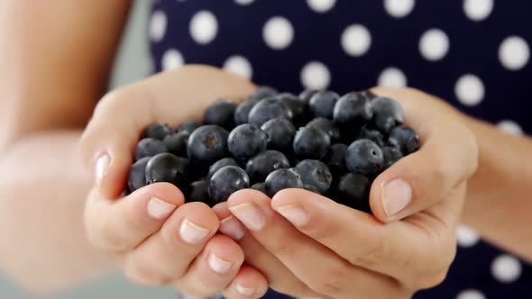 Close-up of woman holding blueberry alt