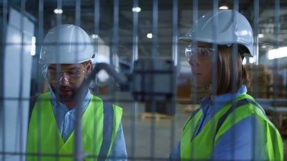 Manufacture Specialists Discussing Production Inspecting Product Warehouse alt