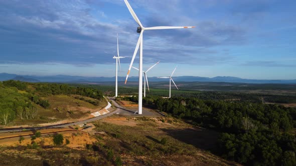 Four Giant Wind Turbines With Propellers Slowly Spinning In The Wind Background With Blue Sky In Sou alt