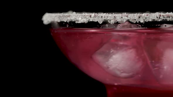 Stirring a Strawberry Cocktail Margarita on Black Background in Macro Shot alt
