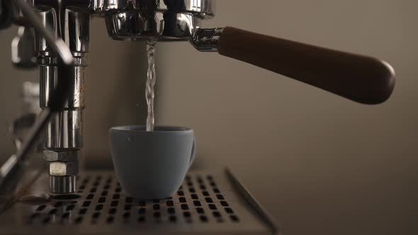 Slow Motion Dark Early Morning Shot of Rinsing Coffee Machine Before Making Esprresso alt