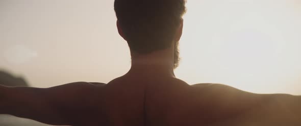 Man stretching his arms by the sea alt