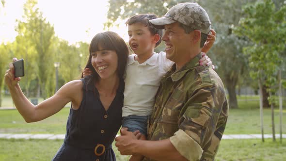 Happy Military Couple with Kids Celebrating Dads Returning alt