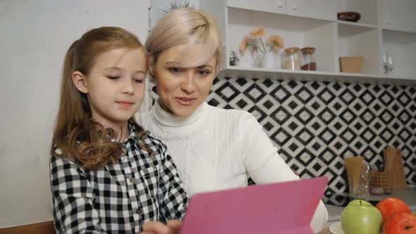 Woman Using Digital Tablet and Spending Time with Daughter