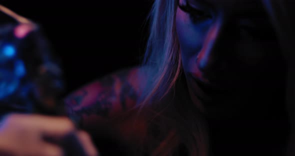 Close up of a young female tattoo master tattooing in her studio. BMPCC 4K alt