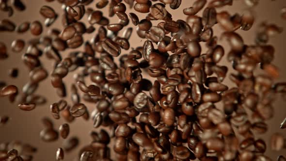 Super Slow Motion Shot of Crashing Coffee Beans on Brown Gradient Background at 1000Fps alt
