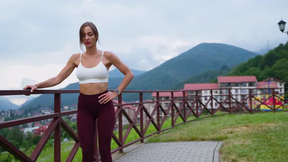 Workout in Park with Picturesque View on Small Town in Mountain Woman is Doing Sport alt