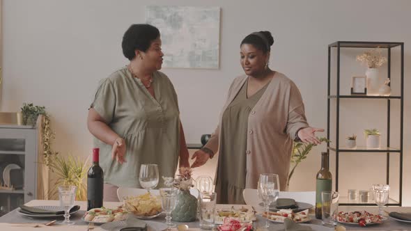 Women Chatting by Dinner Table alt