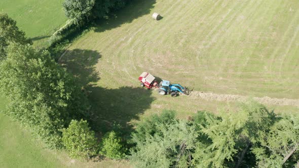 Blue Tractor Hay Bales Trees Aerial View  alt