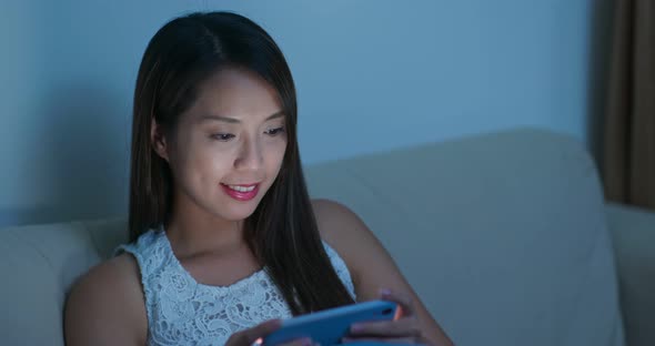 Woman look at smart phone at night alt
