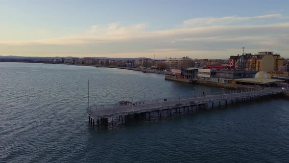 Side View of the Pier on the Black Sea Against the Background of the Sky and Sunset alt