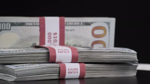 Bundles of Dollars Rotate on Black Background alt
