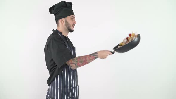 Side View of Professional Chef Tossing Vegetables in a Wok Against White Background alt