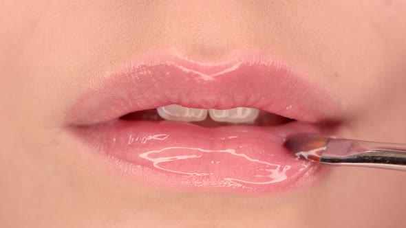Applying lipstick on lips close up