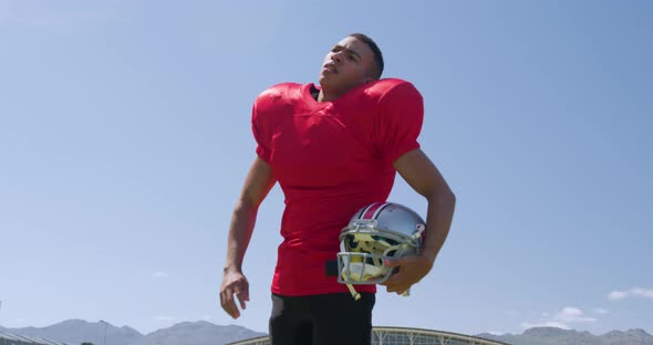 American football player standing with helmet alt