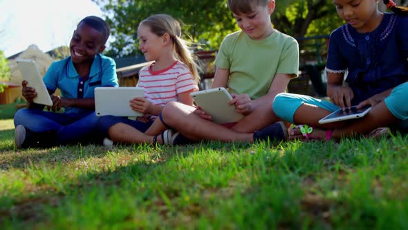 Kids using digital tablet in the playground 4k alt